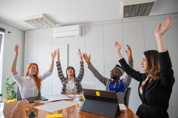 A group of business people with their hands raised to the sky, carefree and relax in the office