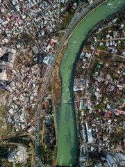 Fototapeta premium Aerial view of Tbilisi cityscape houses and a bridge on a river in Georgia