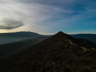 Majestic mountain landscape with sunset cloudy blue sky on the horizon