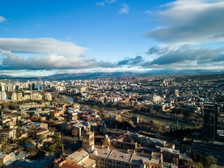 Naklejka premium Aerial view of the cityscape with a cloudy blue sky in the background, Tbilisi, Georgia
