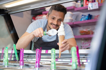 young bearded man in apron standing in food truck