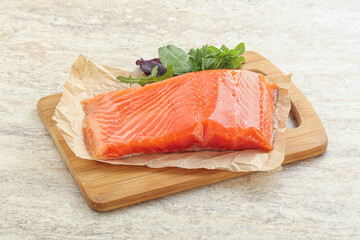 Raw salmon fillet over board