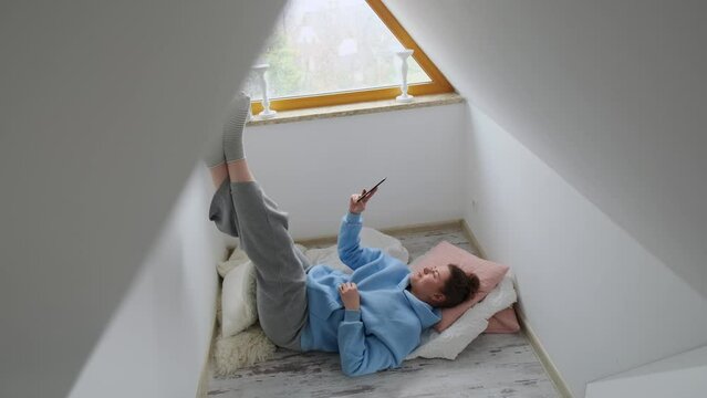 Millenial woman reads e-book in her cozy apartment, 4k