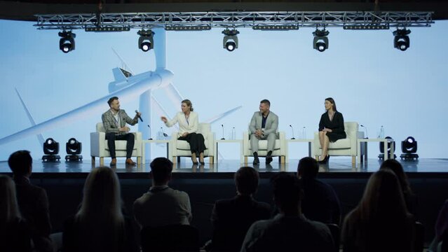 Group of 4 experts speakers are having a conversation on stage during sustainable green eco energy conference 