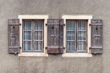 Wooden windows with rustic shutters on an old wall