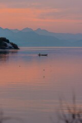 Naklejka premium Vertical shot of a kayak in a lake during a sunset