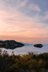 Fototapeta na wymiar Vertical shot of small hills in a lake during a sunset