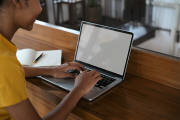 Side view of university student woman typing on laptop, doing homework, working on research project online