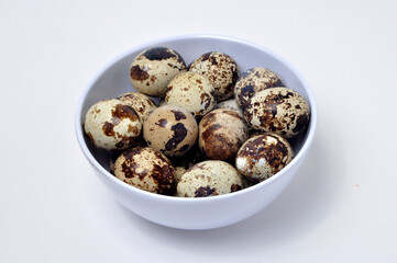 Qual eggs in white bowl selective focus white background
