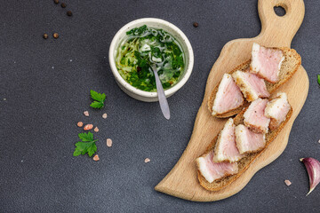 Canapes with rye bread and pieces of salty high-fat meat cooked with spices. Garlic sauce, snack