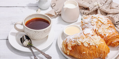 Good morning concept. Breakfast with cup of coffee and fresh croissant. Sweet creamy sauce