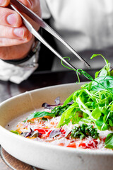 chef hand decorated Fresh healthy tomato carpaccio with balsamic vinegar, cheese and salad