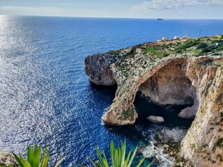 Aerial view of majestic cliffs and a tranquil sea in the background. Blue Grotto, Malta.