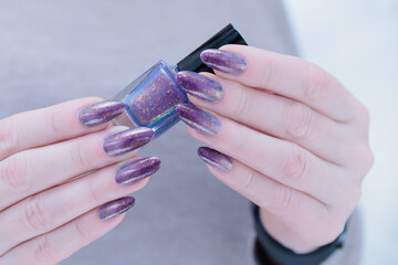 Female hands with long nails with french light blue lilac nail polish