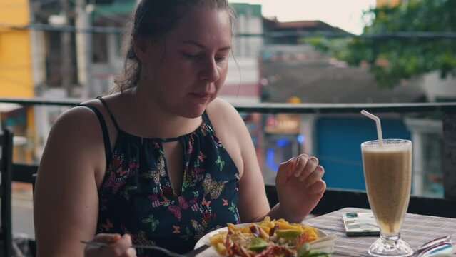 Cute chubby girl eats lobster with french fries in restaurant. Close up.