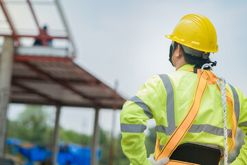 Engineers stand to inspect the construction of a house that is still being built.