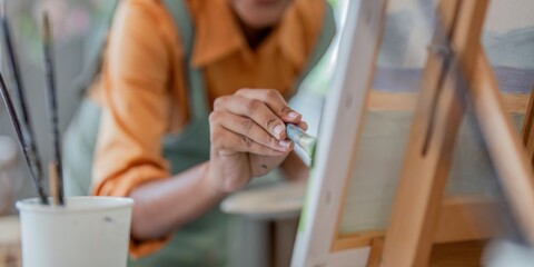 Close up of african american male painter at work painting on canvas in art studio. creation and inspiration at an artists painting studio