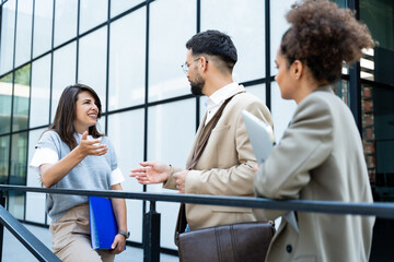 Business people partners colleagues team and staff member last meeting and discussion before summer vacation break. Businessman with two expert businesswomen strategy talk outside office building