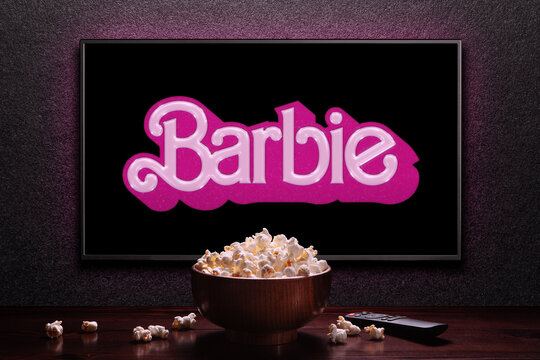 TV screen playing Barbie trailer or movie. TV with remote control and popcorn bowl. Astana, Kazakhstan - July 2, 2023.