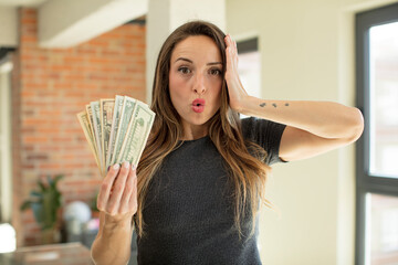 pretty woman feeling extremely shocked and surprised. dollar banknotes concept