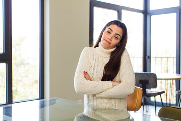 pretty caucasian woman shrugging, feeling confused and uncertain, doubting with arms crossed and puzzled look