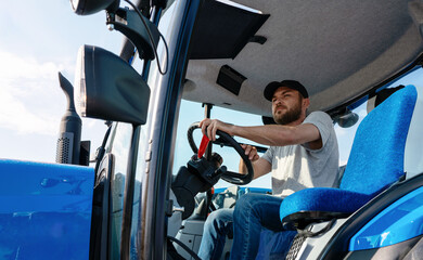 Tractor driver in sitting in agriculture tractor cabin. © Barillo_Images