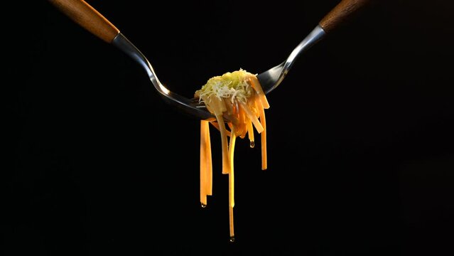 Cooked bigoli pasta twisted on fork with olive oil and parmesan
