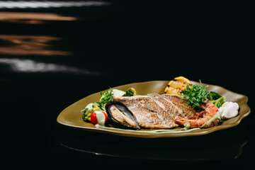 Dorado fillet fish dish on a black background