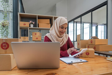 Muslim beautiful woman in hijab working online sales Checking for customer orders in office