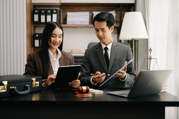 Asian business team and lawyers discussing contract papers sitting at the table. Concepts of law, advice, legal services. at modern office