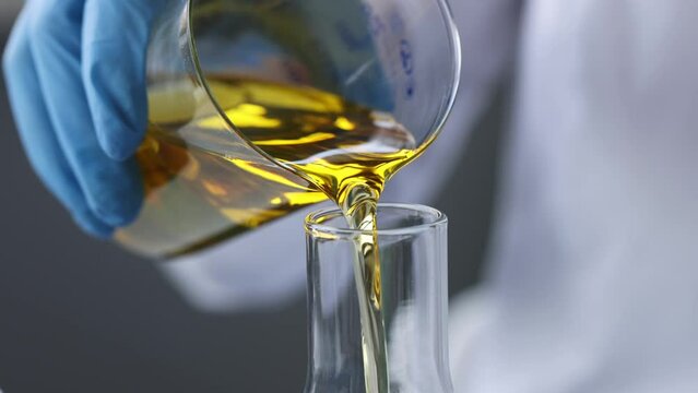 Scientist chemist pouring motor oil into test tube closeup 4k movie. Diesel fuel quality control concept