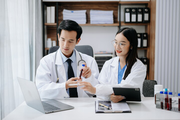 Medical technology network team meeting concept. Asian Doctor hand working with smart phone modern digital tablet and laptop computer with graphics chart interface,