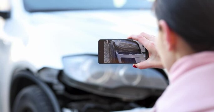 Woman filming broken car on mobile phone 4k movie. Car insurance concept