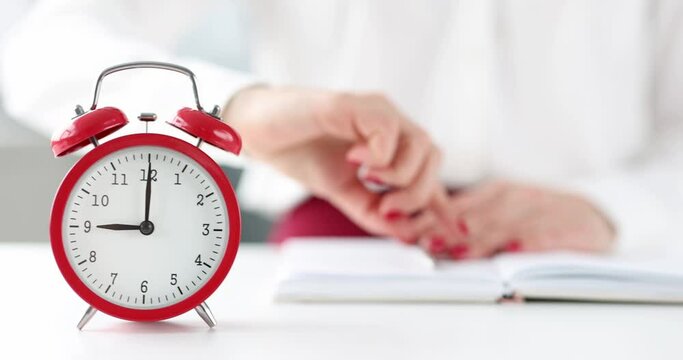 Woman turning off alarm and writing in notebook 4k movie. Begining of work day concept