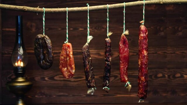 Variety of dried sausage on twine hanging in country wooden barn