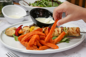 Greek souvlaki, sweet potatoe and tzatziki yogurt dip served on the plate in the restaurant