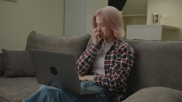 Woman Reading Bad News Using Laptop. Upset white female is nervous about something looking at computer.
