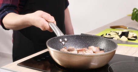 frying meat. pieces of meat in a frying pan. food preparation in the kitchen. cooking at home. close up. 