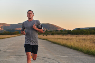 A young handsome man running in the early morning hours, driven by his commitment to health and...