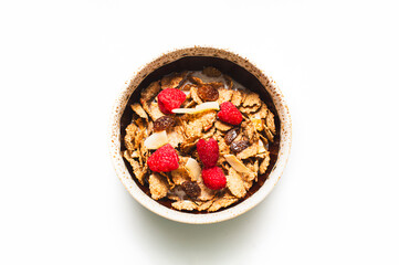 Muesli with raspberries and milk in a bowl on a white background. Healthy breakfasts, proper nutrition