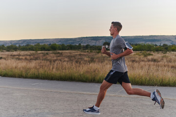 A young handsome man running in the early morning hours, driven by his commitment to health and...