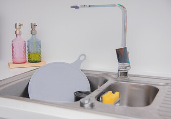 Messy kitchen counter with pile of dirty dishes in sink