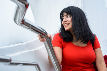 young latin woman sitting on Puente De La Mujer in Buenos Aires, smiling enjoying the vacation day.