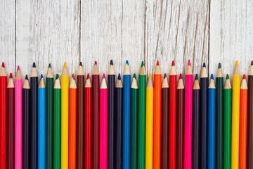 Colored pencil crayons school background on old wood desk