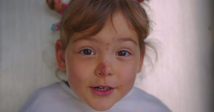 Portrait of a small child of three years old with an abrasion on his face. Close-up of a little girl with a wound on her nose. Scratched baby face. Domestic violence against a child