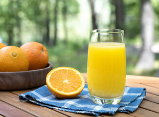 Orange juice in glass with oranges