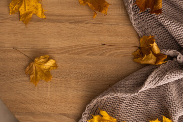 Autumn background with a plaid and with yellow leaves