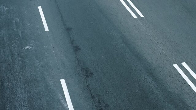 Top close-up timelapse view of many cars and trucks driving fast on the road marking asphalt on speed highway in the evening. Blur motion city traffic background