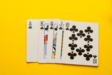 Royal Flush. Five playing cards - the poker royal flush hand on yellow background. Success in gambling.