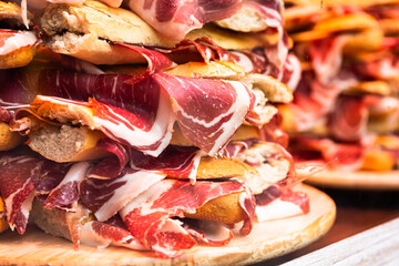 mouth watering sandwiches with jamon laid out in a slide on shop window